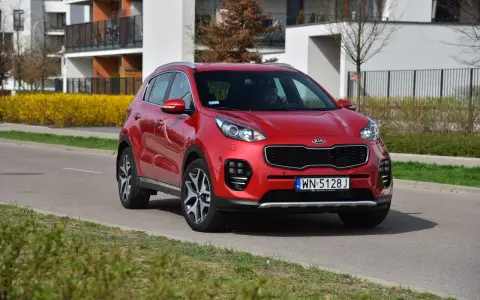 Czerwony Kia Sportage 4 na drodze, gotowy do wymiany żarówki.