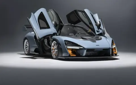 Niebieski McLaren Senna z otwartymi drzwiami, gotowy do startu.