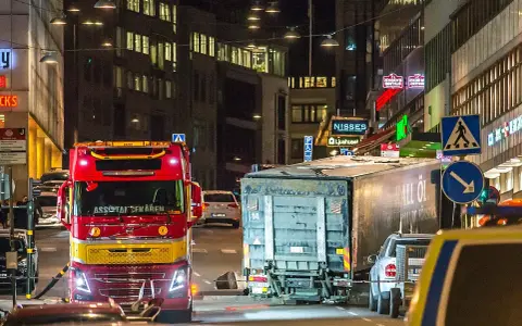 En röd bärgningsbil står vid en lastbil på Drottninggatan, en plats som för alltid är förknippad med terrordådet.