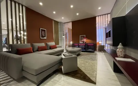 Soggiorno moderno con pareti color terracotta e divano grigio. Effetti pittura pareti moderne che creano un'atmosfera calda e accogliente.