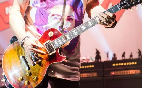 Muzyk gra na gitarze Gibson Les Paul, tworząc dźwięki, które mogłyby znaleźć się na najważniejszych płytach w historii muzyki.