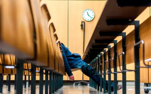Un uomo dorme in un'aula, simbolo della lunga durata processo civile risarcimento.