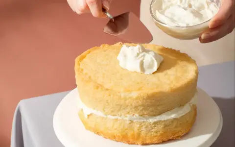 Nakładanie puszystego kremu na biszkoptowe ciasto z mascarpone.