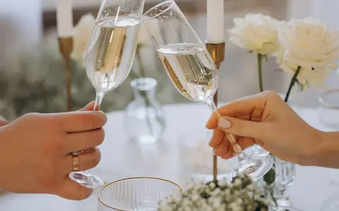 Wznoszenie toastu szampanem. Jakie są zasady serwowania alkoholu na weselu? Wino, wódka czy whisky – wybór należy do pary młodej.