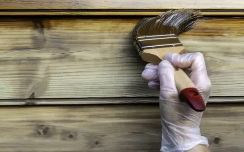 Application d'une lasure ou vernis bois extérieur sur des lames de bois. La protection du bois est en cours.