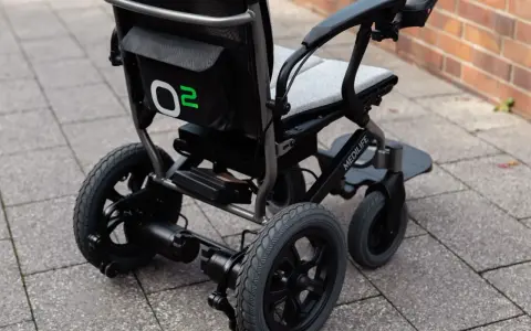 Nowoczesny wózek elektryczny Medilife O2, jeden z wielu rodzajów wózków inwalidzkich, gotowy do jazdy po chodniku.