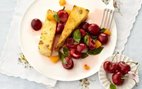 Zwei Scheiben süßer Auflauf mit frischen Kirschen und Aprikosenstücken. Ein köstliches Dessert, das Lust auf mehr Kirschen Rezepte macht.