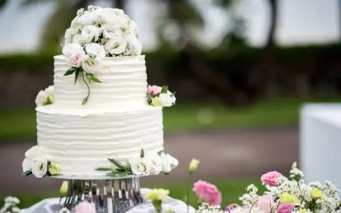 Elegancki, dwupiętrowy tort weselny ozdobiony bukietem białych i różowych, **jakie żywe kwiaty na tort** dodają mu uroku.