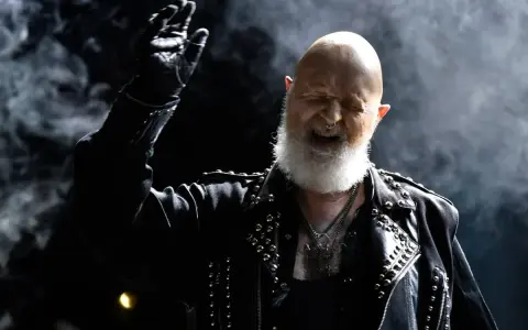 Rob Halford, der offen schwul ist, rockt die Bühne in Lederjacke und mit Bart.