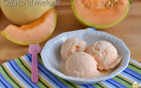 Tre palline di cremoso gelato al melone in una ciotola bianca, con fette di melone fresco sullo sfondo.