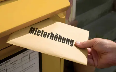 Brief mit "Mieterhöhung" wird in gelben Briefkasten eingeworfen. Wichtige Fristen beachten!