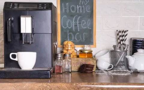 Máquina de café, taza, galletas y un letrero que dice "my Home Coffee bar". Todo listo para disfrutar de un momento de relax en tu zona de cafe en la cocina.
