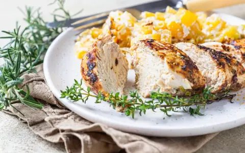 Soczysty indyk z airfryer, pokrojony w plastry, podany z pieczonymi ziemniakami i świeżymi ziołami.