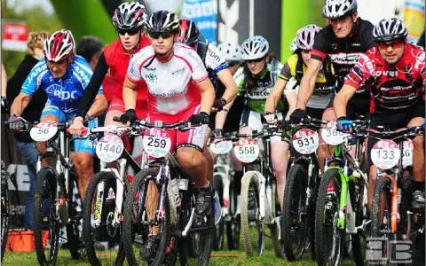 Zawodnicy w kaskach i strojach kolarskich startują w wyścigu mtb bike maraton.