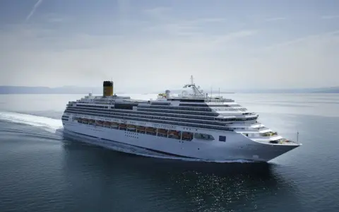 La Costa Favolosa solca il mare calmo, lasciando una scia bianca.