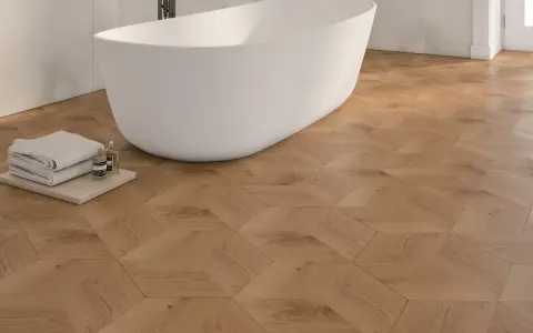 Bagno moderno con vasca freestanding e pavimento in parquet geometrico. Idee bagno con parquet per un tocco di calore e design.