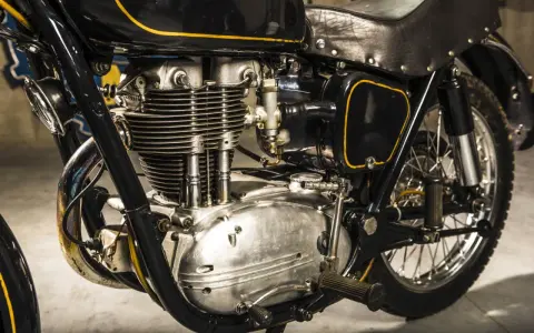 Klasyczny motocykl w czarnym malowaniu z żółtymi wstawkami, gotowy do rejestracji na zabytek. Widoczny potężny silnik i skórzane siodło.