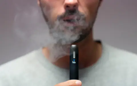 Hombre exhala humo de un vaper blu. Este vaper blu es malo para la salud.