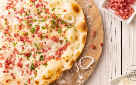 Flammkuchen vegetarisch mit Speckwürfeln, Zwiebelringen und Schnittlauch. Ein Genuss für jeden Gaumen!