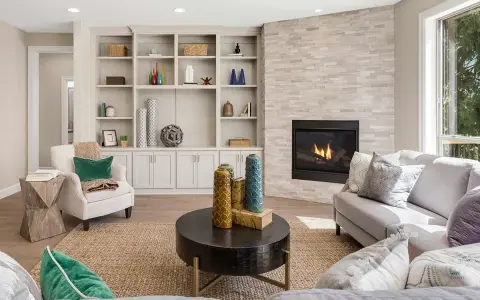 Un elegante mueble salones con chimenea de piedra, estanterías repletas de objetos decorativos y cómodos sofás.