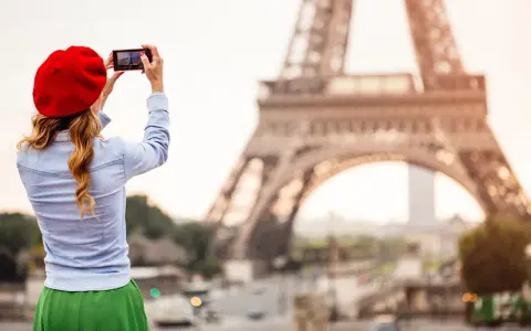 Mujer con boina roja toma foto de la Torre Eiffel. ¡Ideas de qué ver en París!