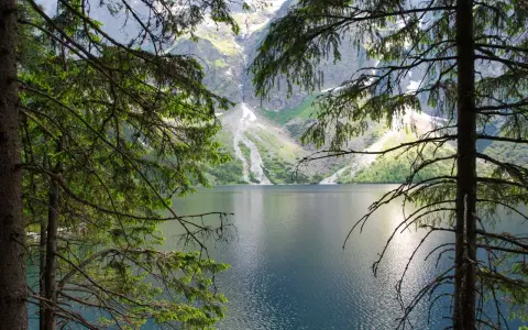 Morskie Oko, Tatry. Spokojna tafla jeziora odbija skaliste szczyty gór.