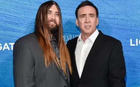 Weston Coppola Cage z długimi włosami i Nicolas Cage na niebieskim tle.
