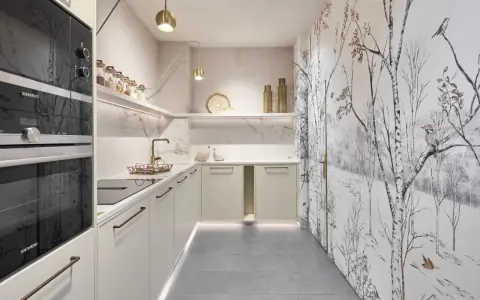 Cocinas pequeñas con encanto: gabinetes color crema, encimeras de mármol, electrodomésticos Siemens y un papel tapiz de bosque invernal.
