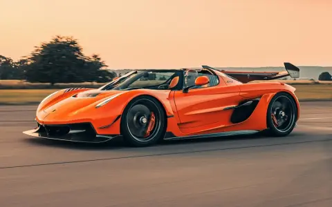 Ein orangefarbener Jesko von Koenigsegg rast auf einer Straße.