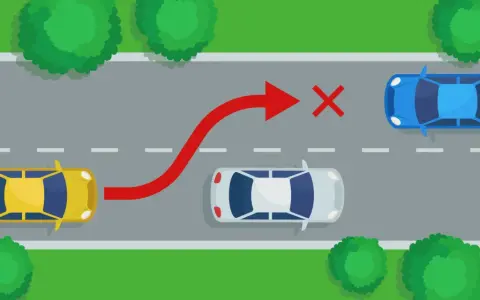 Żółty samochód próbuje niebezpiecznego **wymijania** niebieskiego auta, ignorując białe auto i czerwony znak zakazu.