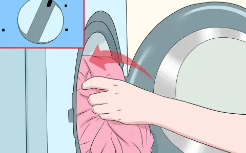Hand lädt rosa Kleidung in die Waschmaschine. Das Programm "Sanft" ist ausgewählt, damit Viskose richtig gewaschen wird.