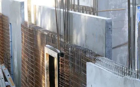 Betonwände mit Bewehrung aus Stahlstäben, bereit für den nächsten Bauabschnitt.