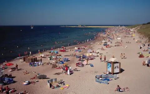 Tłum plażowiczów na piaszczystej plaży, woda i niebo. Czy to Darłówko wschodnie czy zachodnie?