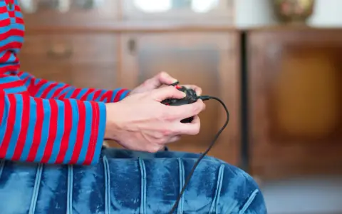 Ręce trzymające kontroler, gotowe do gry. Dowiedz się, jak podłączyć pada od Nintendo Switch do PC, by cieszyć się grami na większym ekranie.
