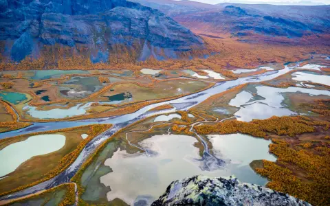 Vacker höstfärgad vy över Kungsleden, med slingrande vattendrag och fjäll. Perfekt tid att vandra.