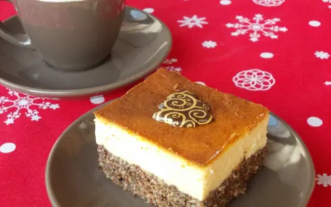 Seromakowiec z gotowej masy makowej i sera z wiaderka bez spodu, ozdobiony czekoladową choinką, obok filiżanki kawy na świątecznym obrusie.