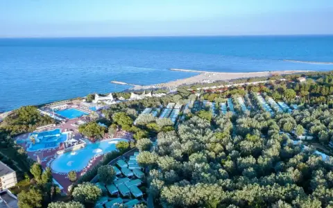 Widok z lotu ptaka na **camping Isamar** z basenami, domkami kempingowymi i plażą nad morzem.