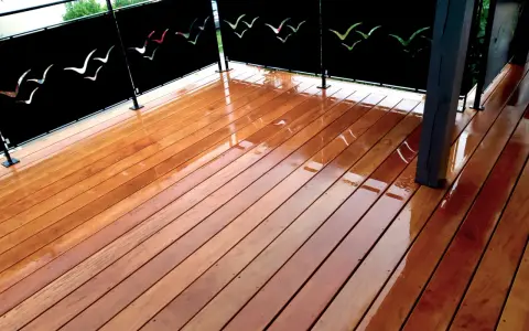 Terrasse privative en copropriété avec un plancher en bois brillant et des panneaux décorés de silhouettes d'oiseaux.