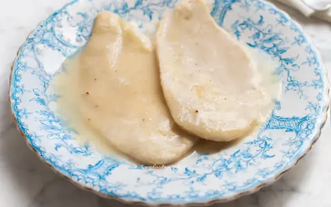 Delicate scaloppine al vino bianco, servite su un piatto decorato con motivi blu.