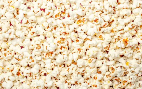 Mnóstwo puszystego popcornu, idealnego na wieczór filmowy. Czy pies może popcorn? Lepiej nie ryzykować, choć wygląda apetycznie!