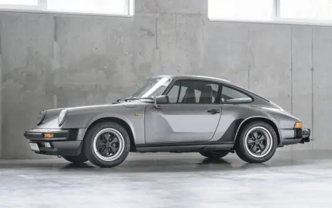 Grauer Porsche 911 G-Modell steht vor einer Betonwand.