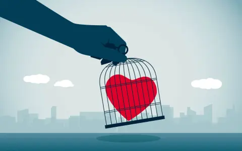 Mano che tiene una gabbia con un cuore rosso dentro, simbolo di esempi di manipolazione emotiva.