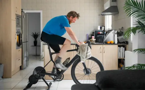 Man doing indoor cycling for beginners in his kitchen.