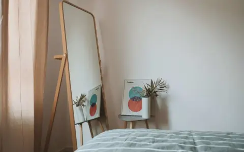 Lustro odbija plakat z kołami i wazon z suszonymi kwiatami. To inspiracja do stworzenia własnej konmari listy porządków.