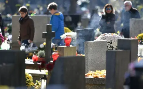 Ludzie odwiedzają groby, zapalają znicze. W powietrzu unosi się dym, symbolizujący modlitwę o odpust zupełny.