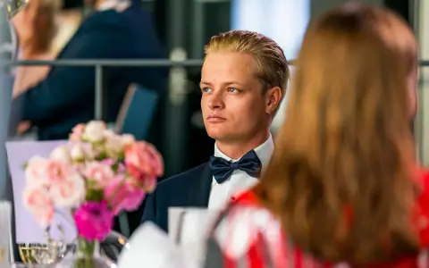 Marius Borg Høiby, klädd i smoking, sitter vid ett bord med blommor.