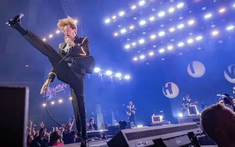 Pelle Almqvist i The Hives levererar en energisk show. Publiken jublar under konserten, en perfekt recension av bandets liveframträdande.