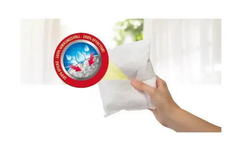 Hand hält Granulat-Beutel für Luftentfeuchter. Das Granulat bindet Feuchtigkeit, die dann als Wasser entsorgt wird. 100% wirkungsvoll.