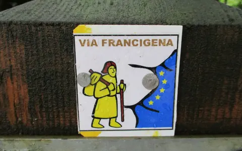 Segnale della Via Francigena, con un pellegrino stilizzato e la bandiera europea. Indica una delle tappe del cammino.