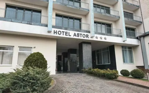 Hotel Astor Jastrzębia Góra – opinie o obiekcie z trzema gwiazdkami. Wejście do hotelu z podjazdem i zielenią.